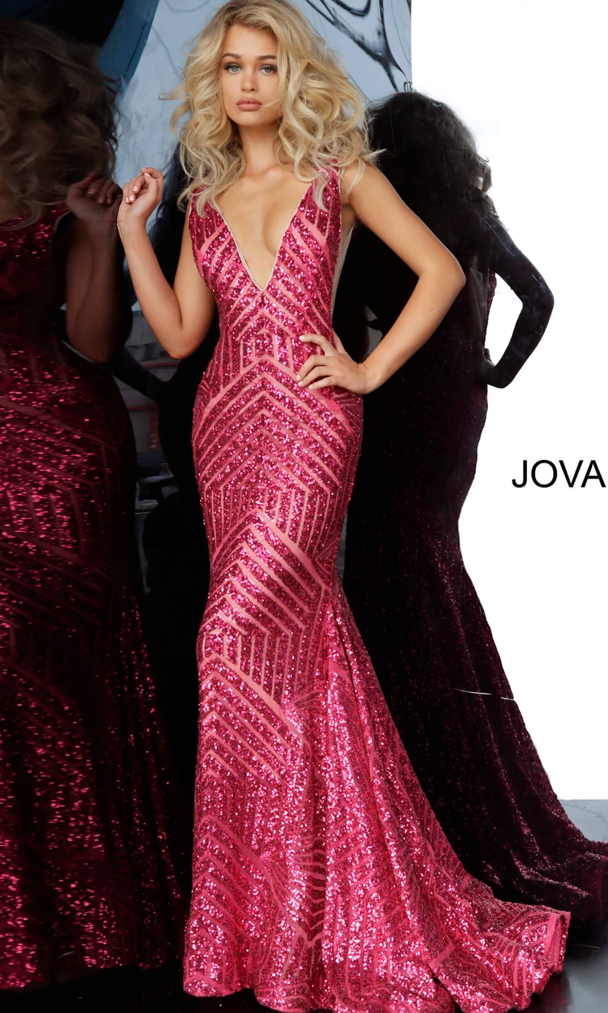 A woman stands in front of a mirror wearing the Jovani Prom Dress with Striped Sequin Pattern, a sleeveless, floor-length pink v-neck gown.
